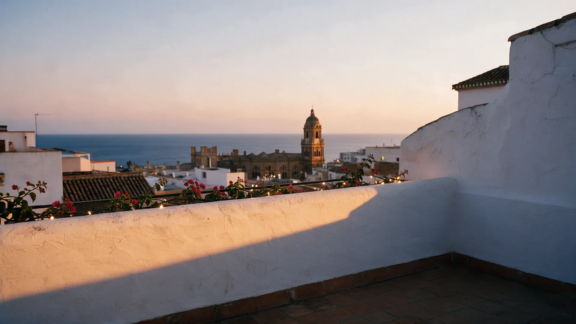 The terrace at golden hour in autumn, lights along the wall.